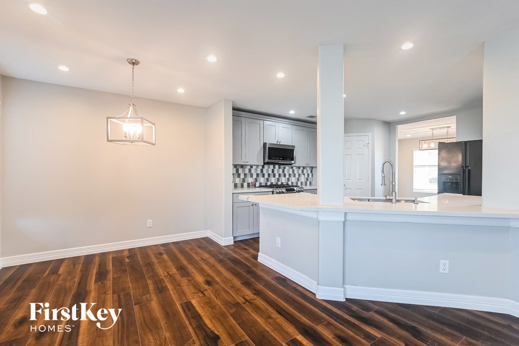 A well-lit, spacious kitchen and living room with wooden floors and a modern design.