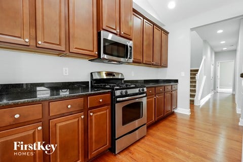 A kitchen with wooden cabinets and a black countertop.