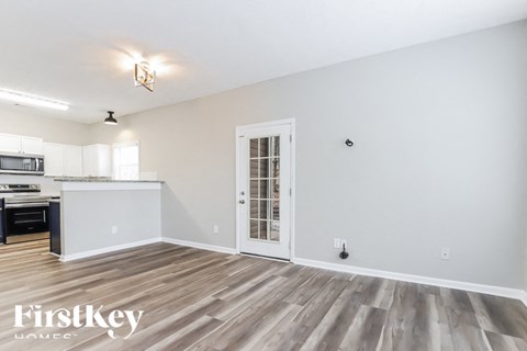 A spacious room with wooden flooring and a white door.