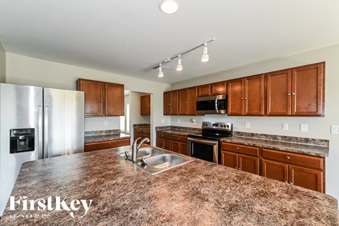 a kitchen with granite counter tops and wooden cabinets