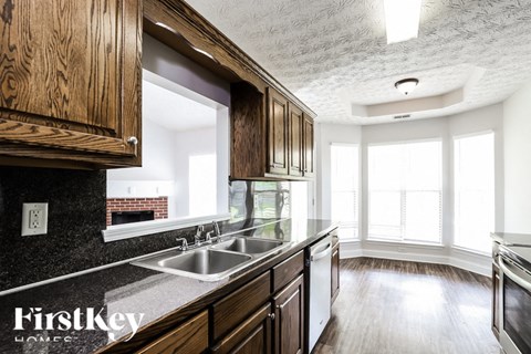 A kitchen with wooden cabinets and a grey countertop.
