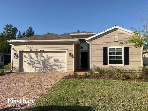 a house with a garage and a brick driveway