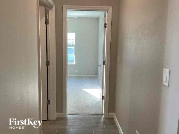 a hallway with a door to a room and a doorway to a bathroom