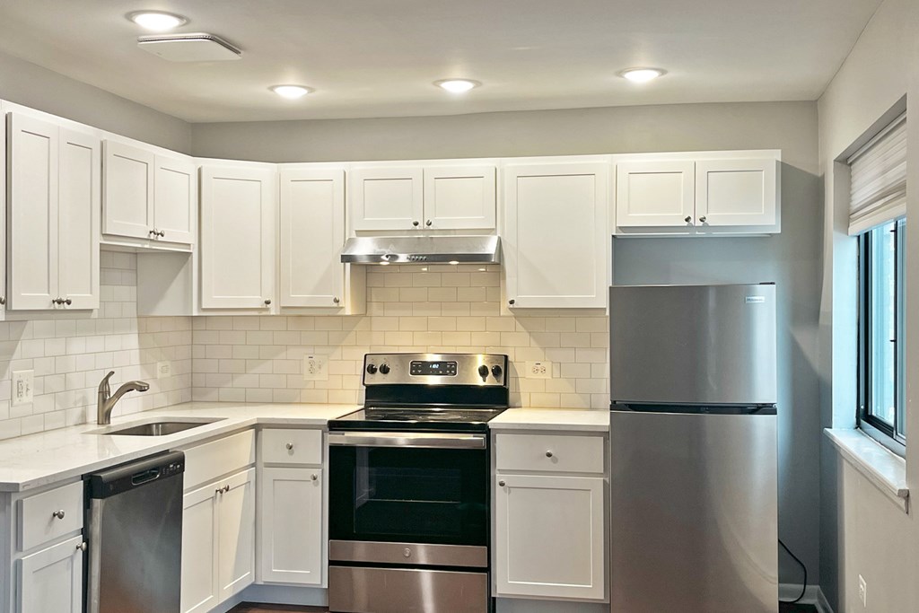 A kitchen with white cabinets and stainless steel appliances.