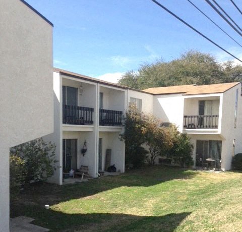 an apartment building with a yard in front of it