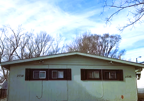 a white house with windows with trees in the background