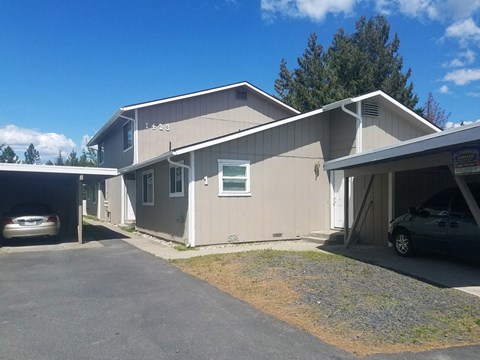 a beige house with a parking lot and a car garage