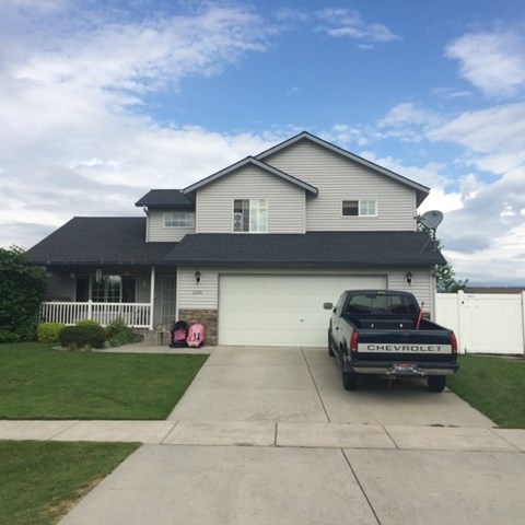 A black Chevrolet truck is parked in front of a house.