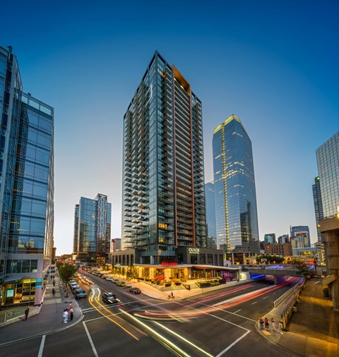 a busy city street with tall buildings at dusk
