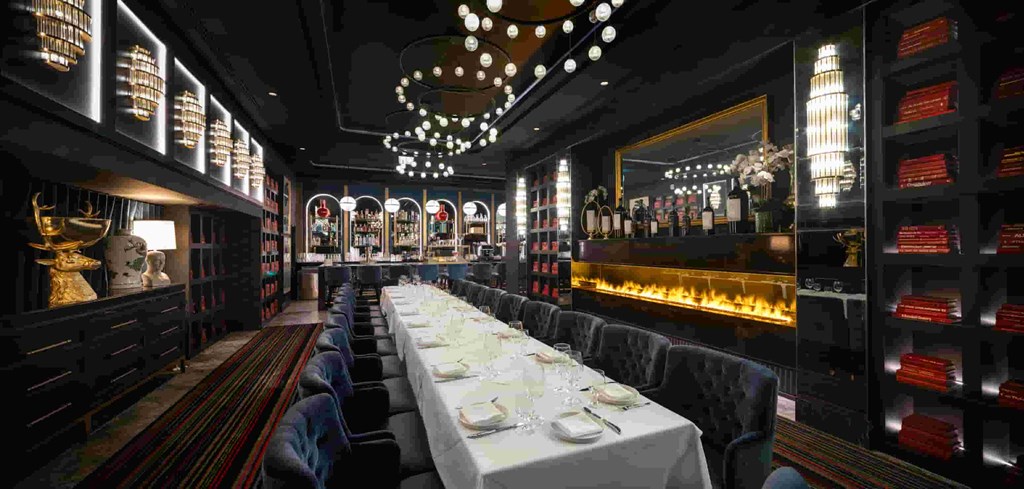 a long table in a restaurant with chairs and a bar