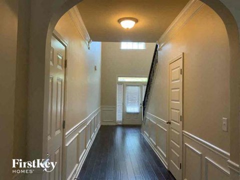a hallway with a wood floor and a white door