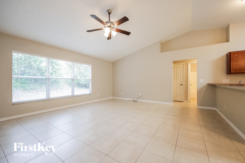 A spacious room with a ceiling fan and a large window.