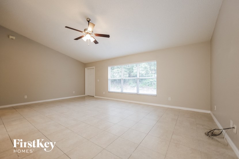 A spacious room with a ceiling fan and a window.