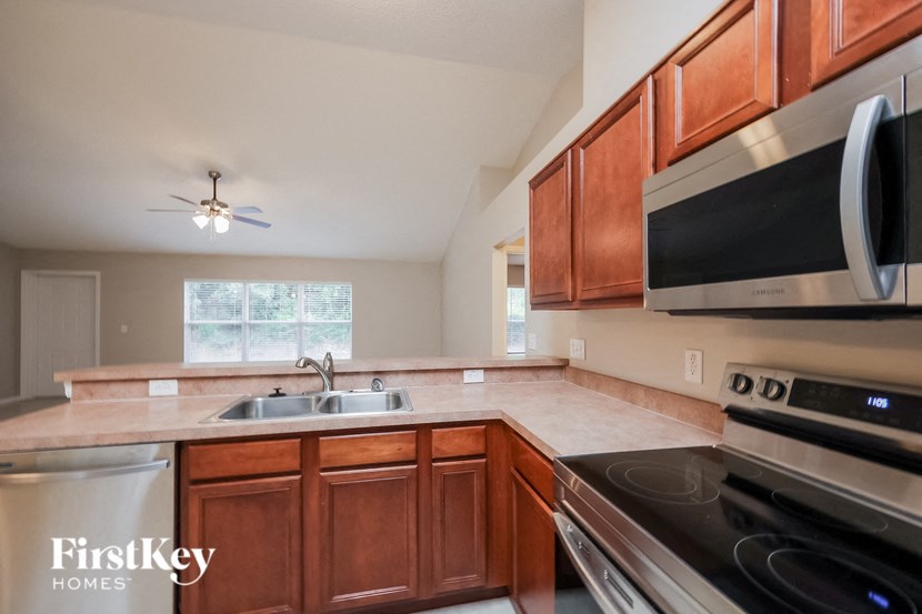 A kitchen with wooden cabinets and a stainless steel oven.