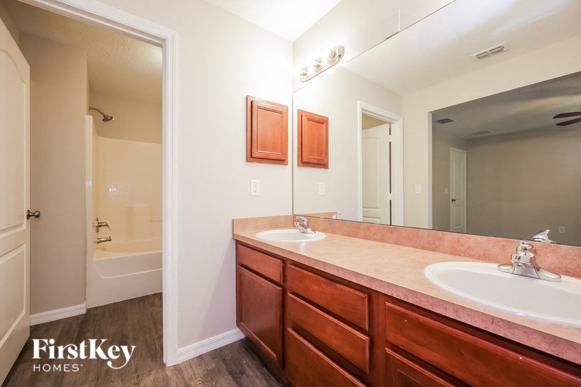 A bathroom with a double sink and a large mirror.
