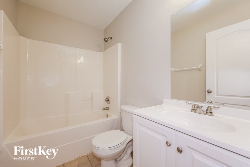 A white bathroom with a tub, toilet and sink.