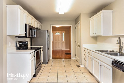 A kitchen with white cabinets and appliances is shown.