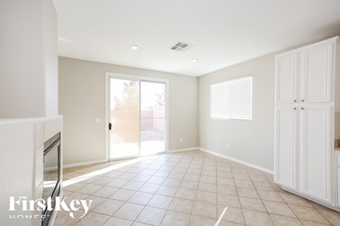 A spacious living room with a television and a sliding glass door leading to a balcony.