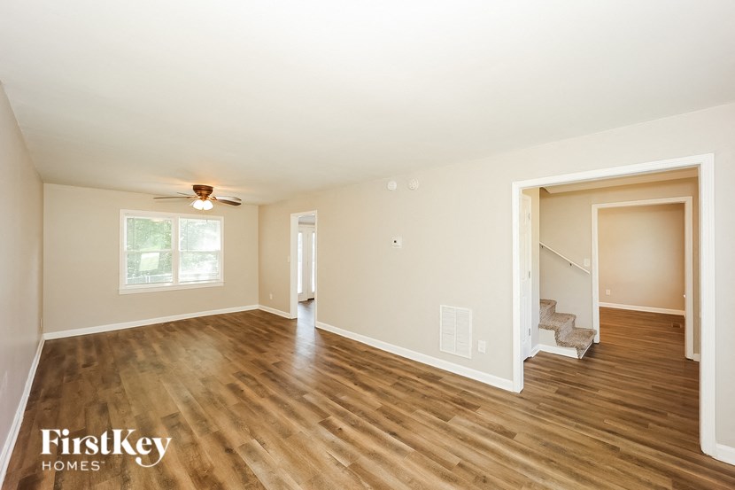 the living room with hardwood flooring and a door to the staircase