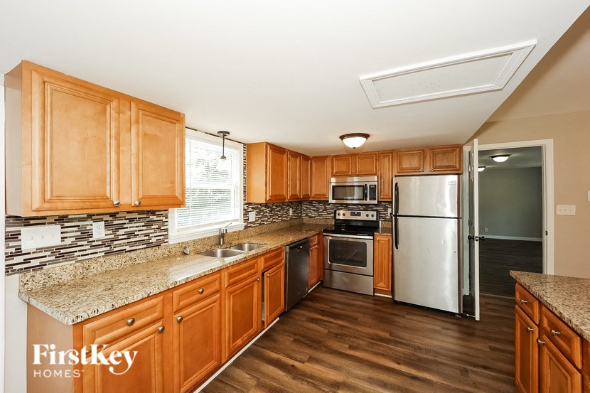 a kitchen with wooden cabinets and stainless steel appliances and granite counter tops
