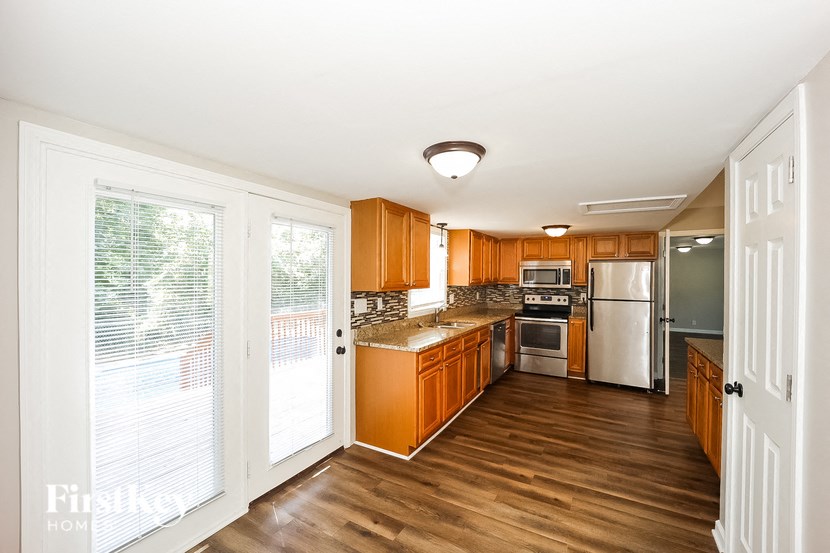 a kitchen with wood floors and wooden cabinets and stainless steel appliances