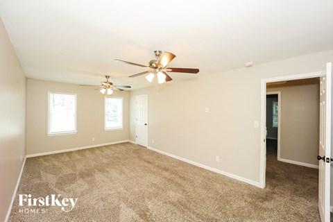 a living room with carpet and a ceiling fan