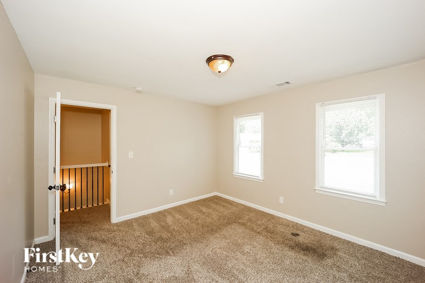 a bedroom with carpeted floors and a door to a closet