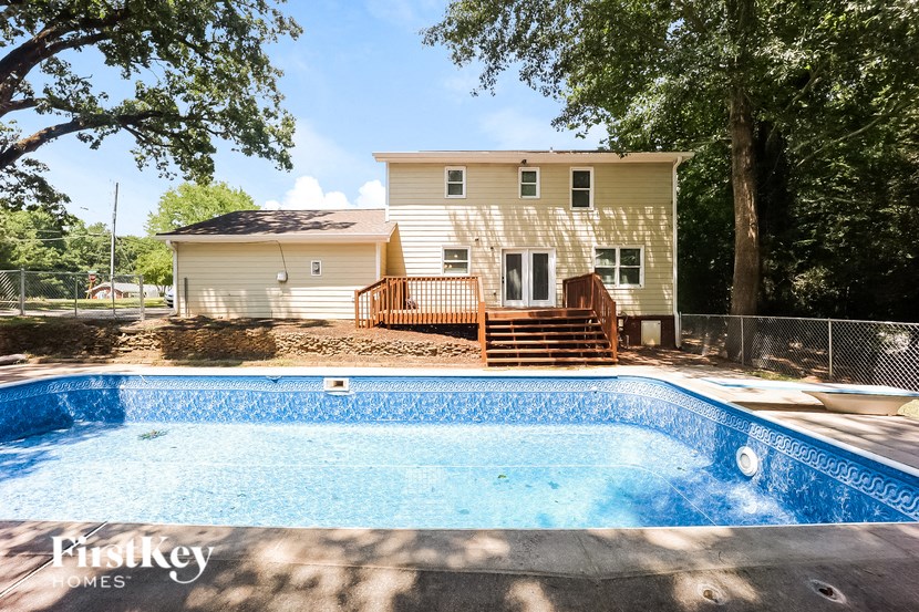 a swimming pool with a house in the background