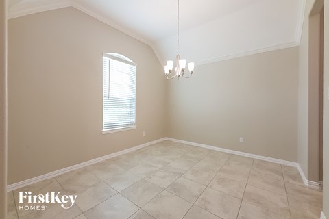 the living room of a home with a tiled floor and a window