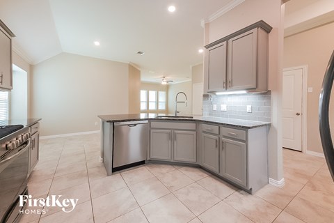 a kitchen with gray cabinets and tiled flooring