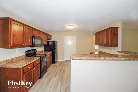 A kitchen with wooden cabinets and a granite countertop.