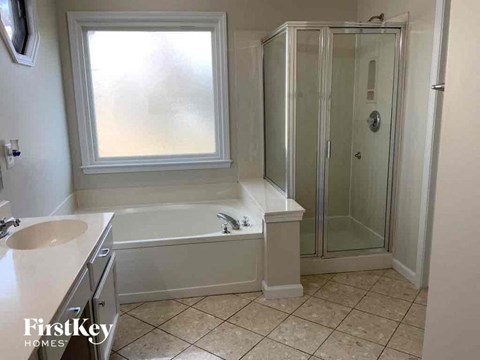 a bathroom with a tub and a shower and a sink