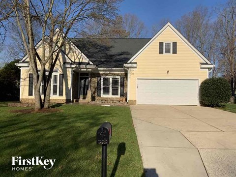 a house with a driveway and a parking meter in front of it