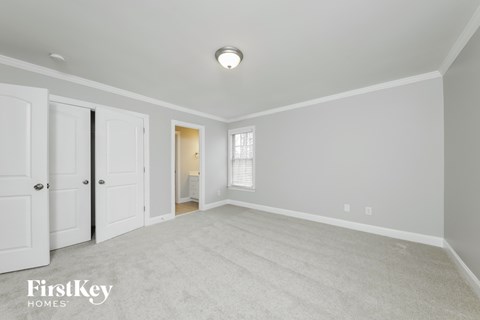 a spacious living room with white carpet and white doors