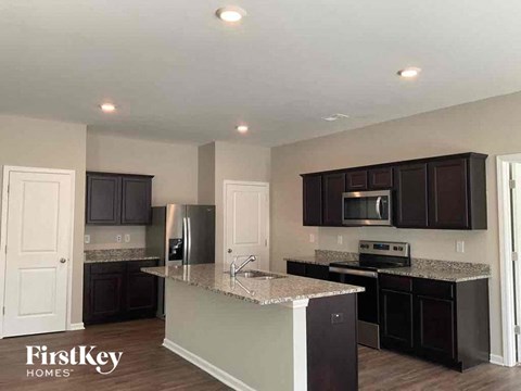 an updated kitchen with black cabinets and granite counter tops