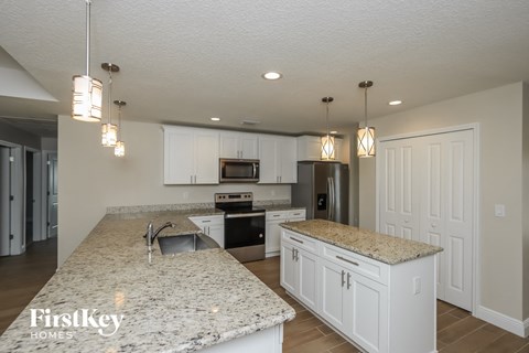 a kitchen with white cabinets and granite counter tops