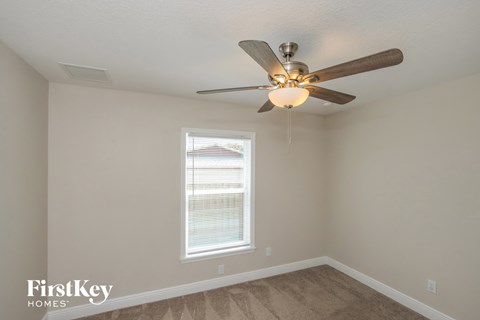 a bedroom with a ceiling fan and a window