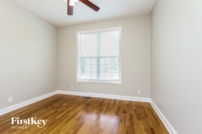an empty room with a window and wooden floors