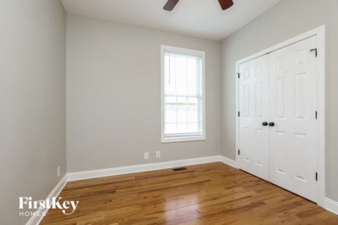 a bedroom with a hard wood floor and a white door