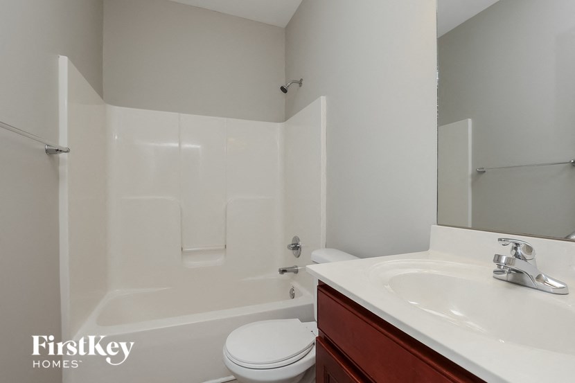a white bathroom with a sink toilet and shower