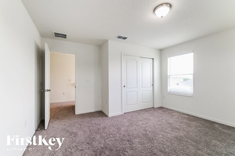 a bedroom with carpet and a door to a closet