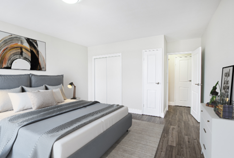 A bedroom with a large bed and a painting on the wall.