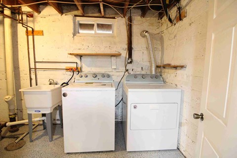 a small room with two washing machines and a sink