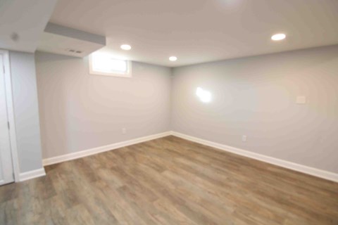 an empty room with white walls and wooden floors