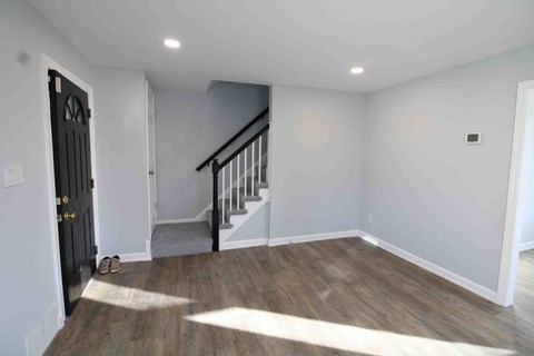 a room with a door and stairs in a house