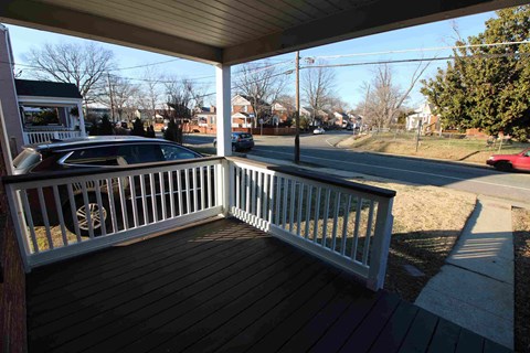 a porch with a car parked on the street
