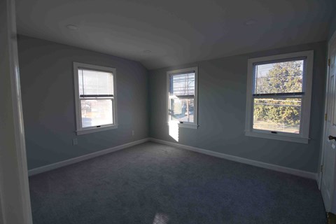 an empty room with two windows in it