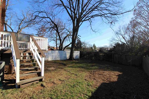 a backyard with stairs and a fence and a tree