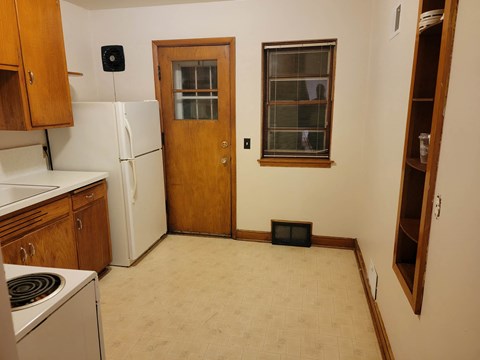 a kitchen with a stove refrigerator and a door
