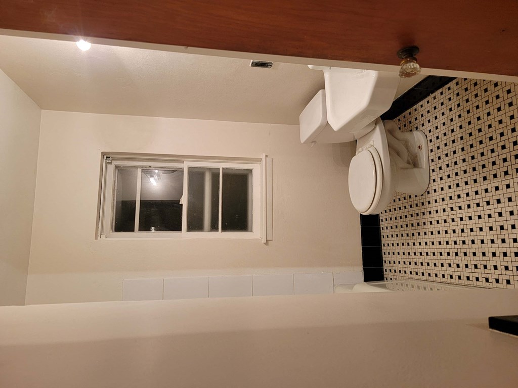 a bathroom with a toilet and a window